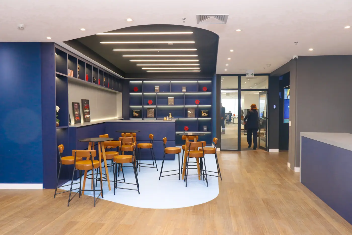 Bar do Espaço Full Sales com mesas altas e cadeiras laranja