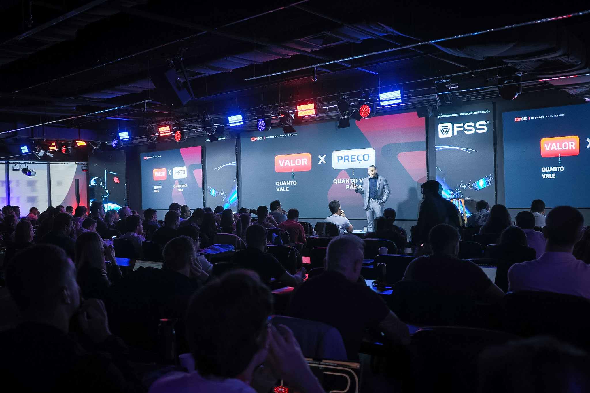 Palco do Espaço Full Sales com 3 telões de LED durante uma palestra